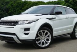 Stylish white Range Rover parked on a road in a green outdoor setting, showcasing its luxury design.