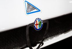 Close-up of an Alfa Romeo emblem on a classic car, emphasizing vintage design.